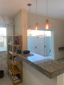 a kitchen with a granite counter top in a room at Villa Tartarugas 2 - Casa Luxo e Conforto - 50m da Praia de Guriri in São Mateus