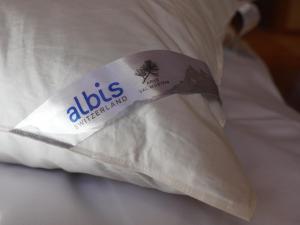 - un oreiller sur un lit muni d'une étiquette dans l'établissement Apartment Giferblick by Interhome, à Gstaad