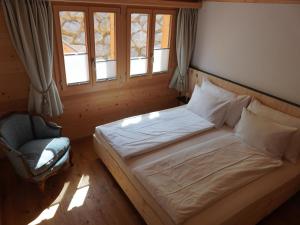 グスタードにあるApartment Giferblick by Interhomeのベッドルーム1室(ベッド1台、椅子、窓付)