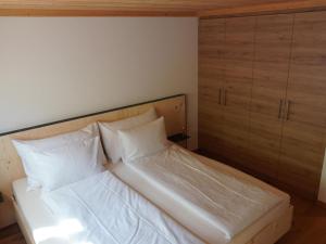 - un lit avec des draps et des oreillers blancs dans l'établissement Apartment Giferblick by Interhome, à Gstaad