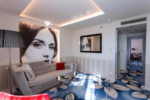 a living room with a couch and a picture of a woman at Grand Hotel Slavia in Ba&scaron;ka Voda