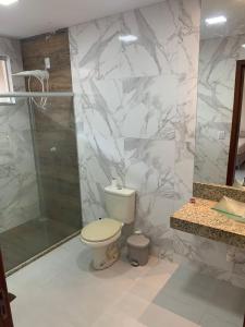 uma casa de banho com um WC e um chuveiro em Villa Tartarugas 2 - Casa Luxo e Conforto - 50m da Praia de Guriri em São Mateus