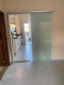 uma sala de estar com uma porta de correr e uma cozinha em Villa Tartarugas 2 - Casa Luxo e Conforto - 50m da Praia de Guriri em São Mateus