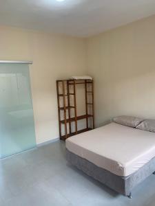 um quarto com uma cama e uma estante de livros em Villa Tartarugas 2 - Casa Luxo e Conforto - 50m da Praia de Guriri em São Mateus