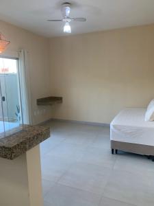 een witte slaapkamer met een bed en een raam bij Villa Tartarugas 2 - Casa Luxo e Conforto - 50m da Praia de Guriri in São Mateus