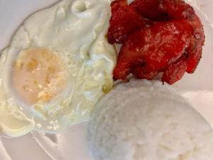 a plate of food with rice and an egg at Park Bed and Breakfast Hotel Pasay in Manila