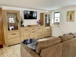 ein Wohnzimmer mit einem Sofa und einem Flachbild-TV in der Unterkunft Holiday Home Sissi by Interhome in Großschönau