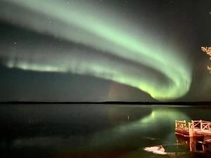 an aurora in the sky over a body of water at Holiday Home Vanttausranta by Interhome in Oikarainen