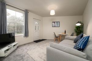 a living room with a couch and a tv at Watling Apartments Tamworth in Tamworth