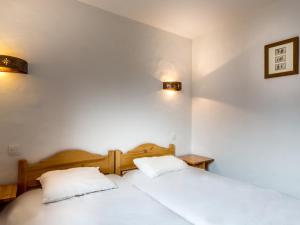 2 letti in una camera con pareti bianche e lampade di Appartement Val-d'Isère, 2 pièces, 6 personnes - FR-1-519-11 a Val dʼIsère