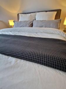 a bed with a black and white comforter on it at Voll ausgestattetes 2 Zimmer Apartment Sanssouci in Osnabrück