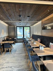 a dining room with wooden tables and chairs at Hotel Garni Ehrenreich in Sölden