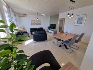 un soggiorno con un tavolo e un divano di NIKO LUX Apartment with Jacuzzi only 70m from the beach a Dramalj
