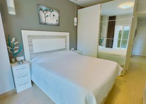 a bedroom with a white bed and a large mirror at Modern Renovated One Bed Apartment in Edificio Apolo Marbella Center in Marbella +25 photos