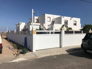 a white fence in front of a white house at casa luis in Costa de Antigua