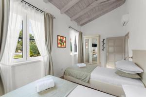 ロヴィニにあるVilla My Vladanの白いベッドルーム(ベッド2台、窓付) +40枚の写真