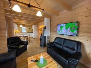 a living room with leather furniture and a flat screen tv at Holiday Home Chalet Sven by Interhome in Spiegelau +42 photos