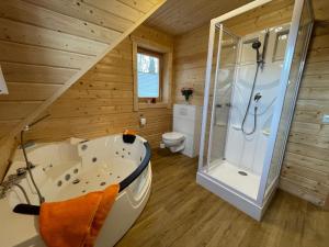 uma casa de banho com uma banheira, um chuveiro e um WC. em Holiday Home Chalet Sven by Interhome em Spiegelau