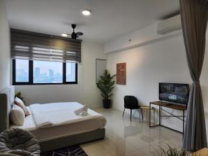 Un dormitorio con una cama y un televisor de pantalla plana. en Chambers Residences Suites KLCC, en Kuala Lumpur