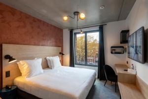 a bedroom with a bed and a desk and a window at Quai Central in Tourcoing