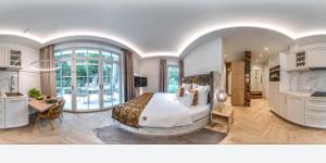 a bedroom with a large bed and a large window at SCHLOSSRESIDENZ - Boutique Apartments & Hotel Suiten in Schloß Ricklingen