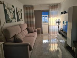 sala de estar con sofá y TV en SEAVIEW APARTMENT LA COLINA en San Agustin