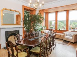 a dining room with a table and chairs and a fireplace at The Old Rectory in Largs