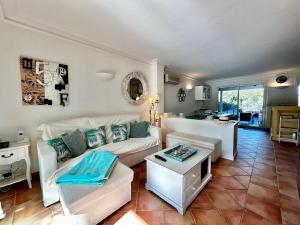 a living room with a white couch and a table at Marinabay 5 in Grimaud