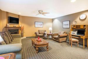 a living room with a couch and chairs and a table at Ramada by Wyndham Spirit Lake/Okoboji in Spirit Lake