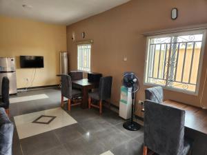 uma sala de estar com mesa e cadeiras em See Good Guest House Enimarire em Sangotedo