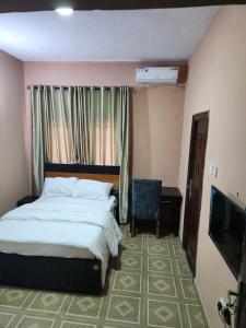 SangotedoにあるSee Good Guest House Enimarireのベッドルーム(ベッド1台、テレビ、椅子付)