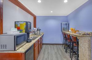 a kitchen with a counter with a microwave and a bar at Days Inn by Wyndham Savannah in Savannah