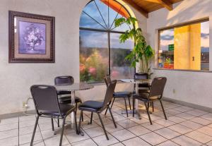 a dining room with two tables and chairs and a window at Super 8 by Wyndham Vernon in Vernon