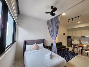 Un pequeño dormitorio con una cama y una cocina. en Chambers Residences Suites KLCC, en Kuala Lumpur