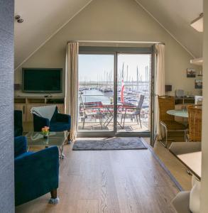 a living room with a view of a marina at Ostsee - Appartement Nr 25 "Godetied" im Strand Resort in Heiligenhafen