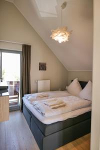 ハイリゲンハーフェンにあるOstsee - Appartement Nr 25 "Godetied" im Strand Resortの窓付きの客室の大型ベッド1台分です。