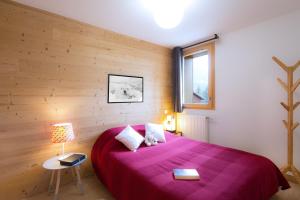 - une chambre avec un lit violet et une fenêtre dans l'établissement Résidence Neige et Soleil by Leavetown Vacations, à Les Deux Alpes