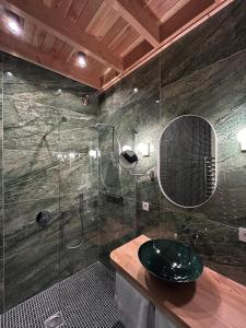 a bathroom with a glass shower and a sink at Cabanes avec jacuzzi les pieds dans la vignes 