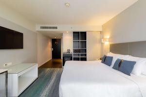 ein Hotelzimmer mit einem großen Bett und einem Flachbild-TV in der Unterkunft Best Western Sukhumvit 20 in Bangkok