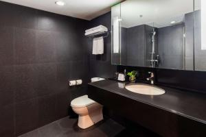 a bathroom with a sink and a toilet and a mirror at Best Western Sukhumvit 20 in Bangkok