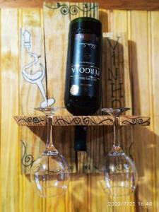 Rancho Toa-toa próximo a Gonçalves MG في سابوكاي ميريم: زجاجة من النبيذ موضوعة على رأس كأسين من النبيذ