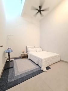 a white bedroom with a bed and a ceiling fan at One Sweet Homestay Kulim Hi-Tech utk Msliim shj in Kulim