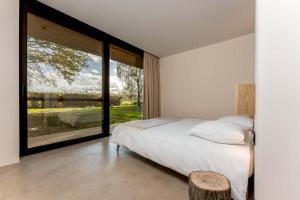 1 dormitorio con cama y ventana grande en Equilodge 't Blommeke - Reconnect with nature, en Brujas