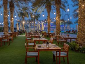 杜拜的住宿－Life Above Clouds，一间设有桌椅的餐厅,种植了棕榈树