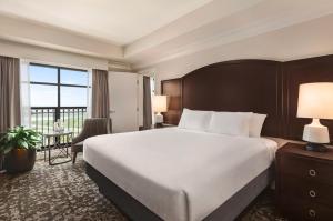 基西米Embassy Suites by Hilton Orlando Lake Buena Vista South的配有一张大床和一张书桌的酒店房间