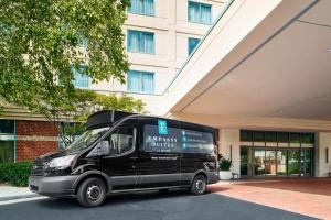una furgoneta negra estacionada frente a un edificio en Embassy Suites by Hilton Raleigh Durham Research Triangle en Cary
