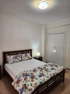 a bedroom with a bed with a floral comforter at Joli appartement en plein centre de Rabat in Rabat