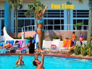 Eine Frau im Bikini springt in ein Schwimmbad in der Unterkunft 1 BR Direct Oceanfront Condo Wyndham Ocean Walk Resort - Daytona Funland 703 in Daytona Beach