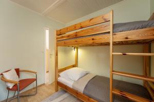 a bedroom with two bunk beds and a chair at Ferienhaus Schneider, Snieder's Hoeg in Grömitz