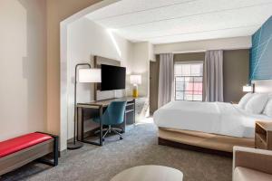 a hotel room with a bed and a desk with a computer at Comfort Suites Ocean City West in Ocean City +34 photos